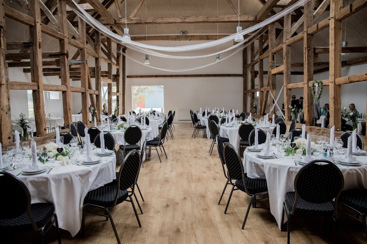 A beautifully set rustic wedding reception venue with round tables and elegant decor.