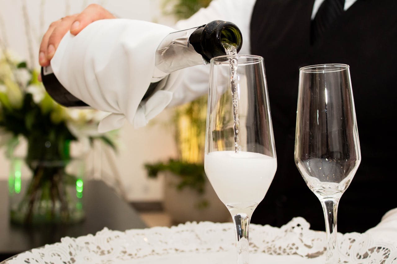 Close-up of champagne being poured into glasses at a sophisticated celebration.