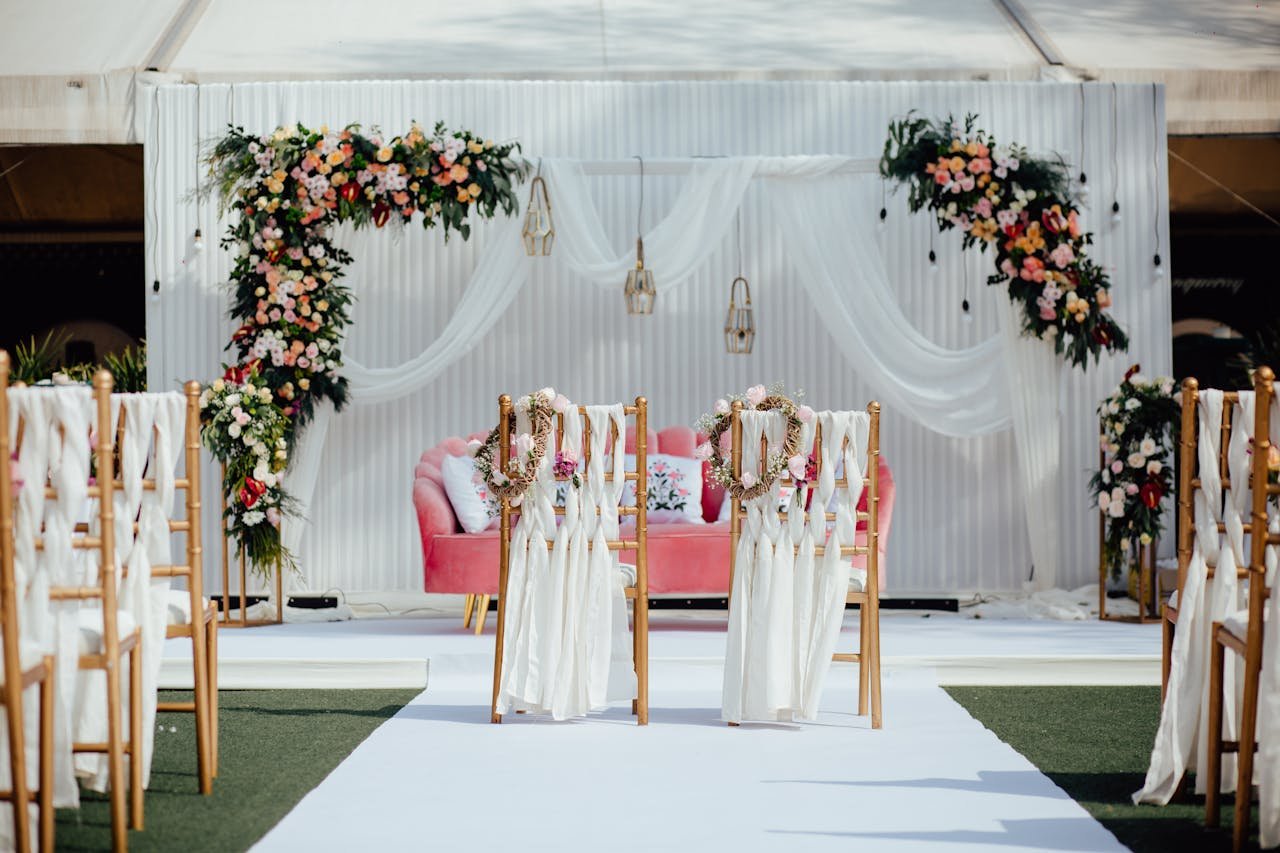 Beautifully decorated outdoor wedding venue with floral arches and elegant seating arrangement.